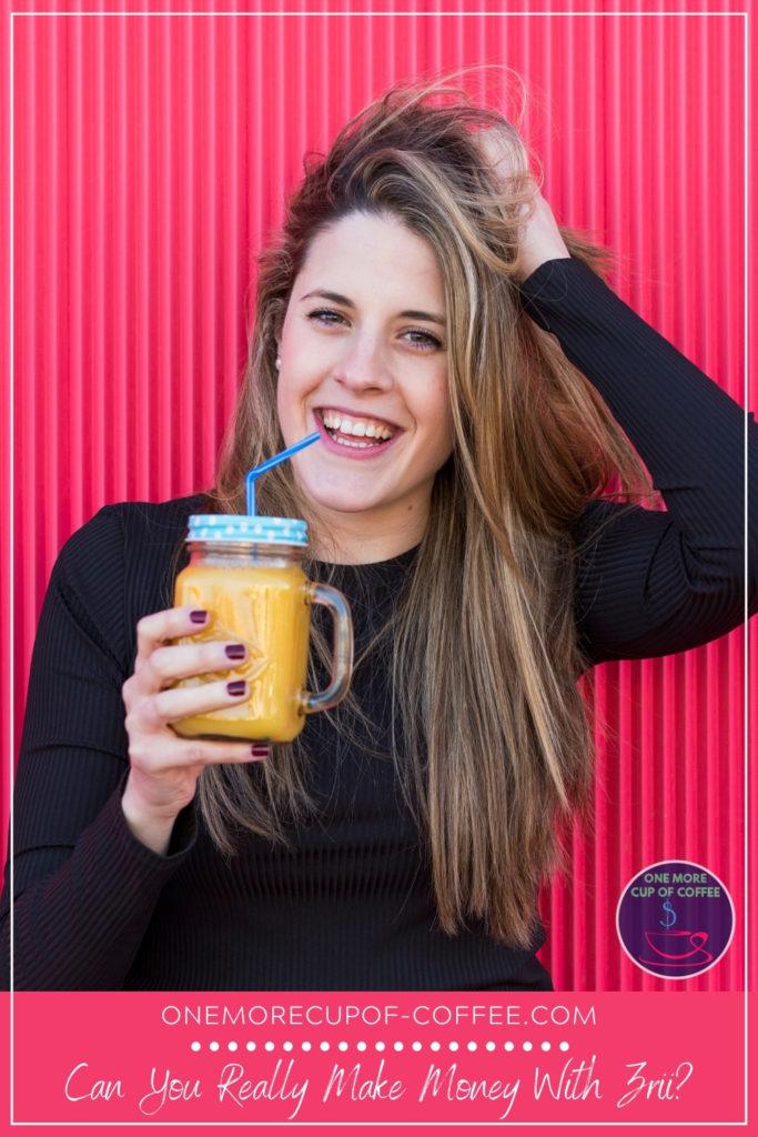 a smiling long-haired woman in black sweater holding a mason jar with orange juice against a pink wall, with text overlay at the bottom "Can You Really Make Money With Zrii?"