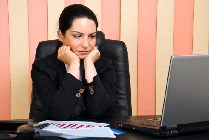 Woman sitting at her desk looking worried as an example of jobs for people with anxiety