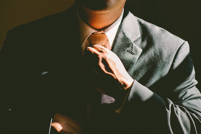 Man adjusting his necktie as an example of jobs for business majors