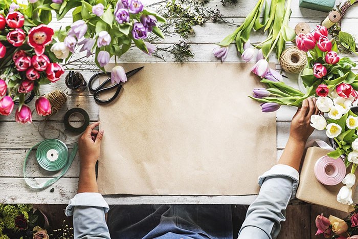 Woman florist arranging flowers on a table as an example of jobs for creative people