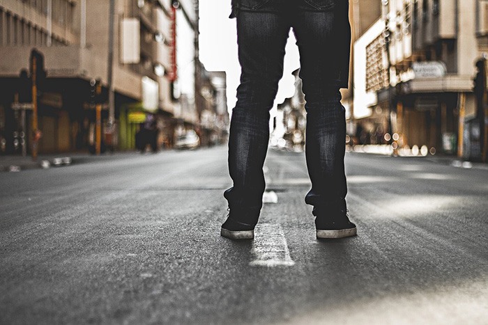 Man standing alone on an empty street as an example of jobs for loners.