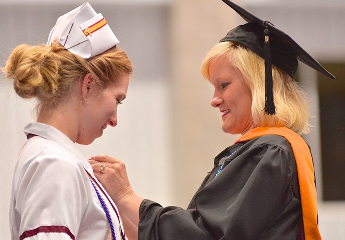 Younger woman attending her nursing graduation ceremony after finishing school