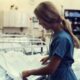 Picture of a woman working as a nurse changing the linen on a patients bed as an example of moonlighting jobs for nurses