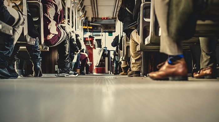 People commuting to work on a bus as an example of workers who don't have a drivers license