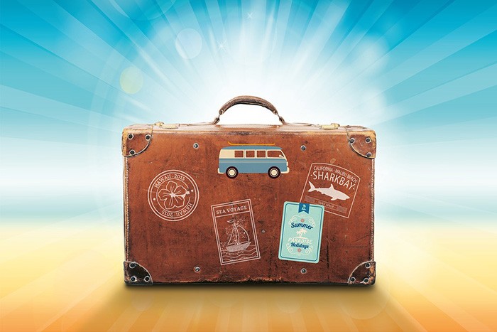 Photo of a suitcase donned with travel stickers as an example of getting paid to write about travel