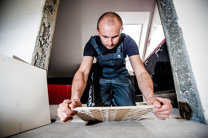 Photo of a man laying tile as an example of how to articles