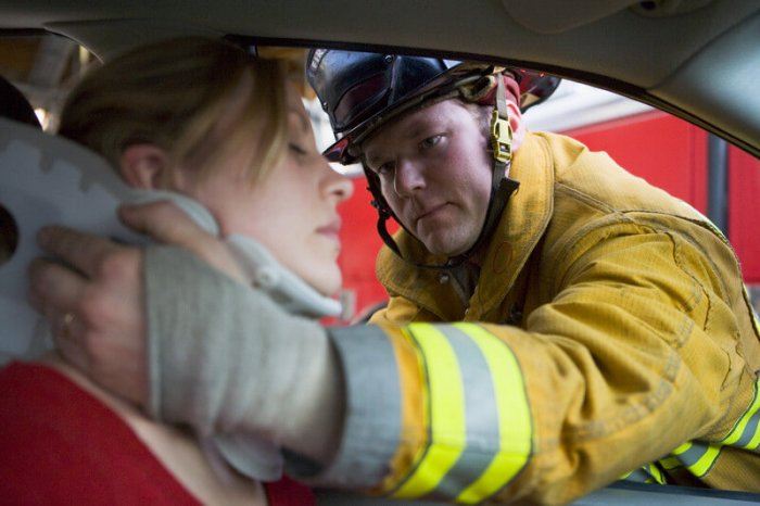 Firefighter helping a women with an injured neck in the car