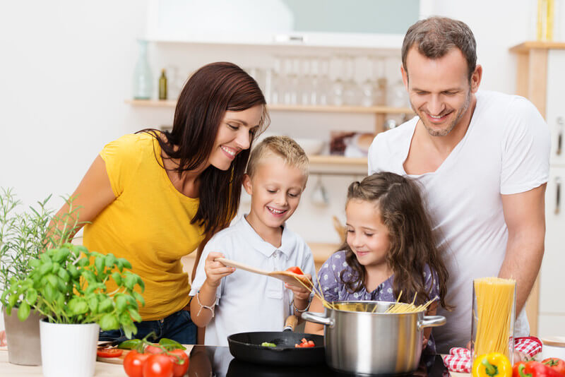 Young family in a kitchen preparing dinner.