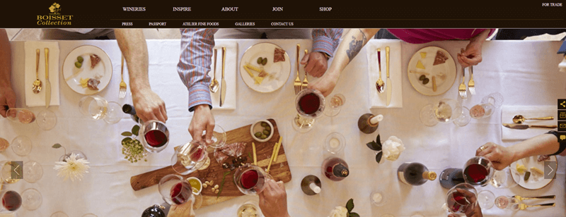 Boisset Collection showing an overhead view of a dinner table with guests clinking glasses of wine with one another. 