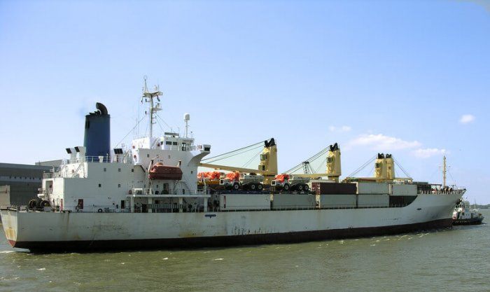 dirty ship liner with cargo sitting on water