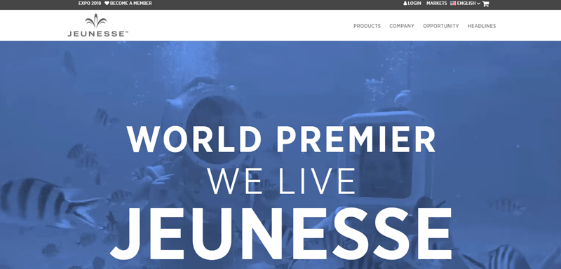 Jeunesse Global website screenshot showing a blue background with two divers deep underwater. 