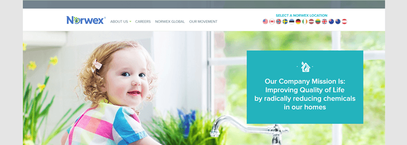 Norwex website screenshot showing a toddler in a brightly lit kitchen, smiling at the camera. 