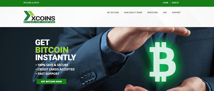 xCoins website screenshot showing a business man who appears to be holding a neon Bitcoin symbol between his hands. 