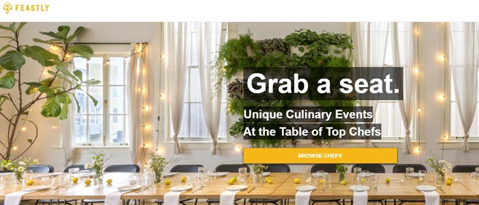 Feastly website screenshot showing a long table with plates, napkins, lemons and flower arrangements. 