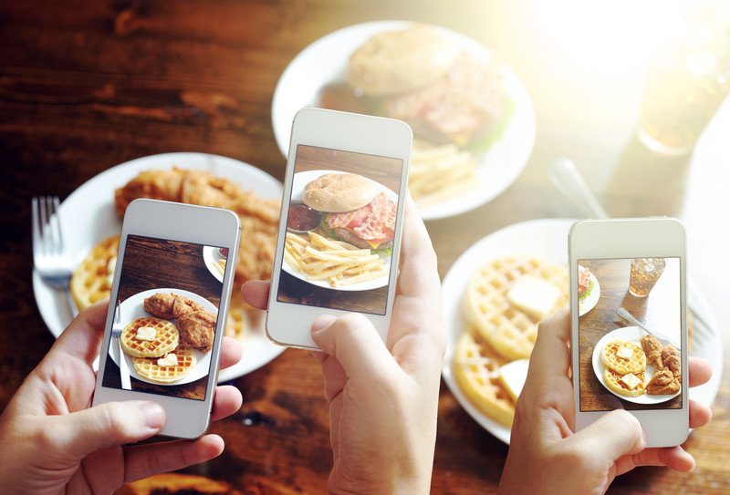 Friends taking photos of food for Instagram