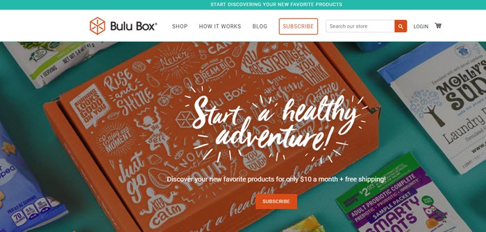 Bulu Box website screenshot showing the box surrounded by a few samples and snacks. 