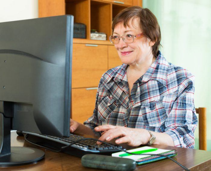 older woman working on the computer during her retirement