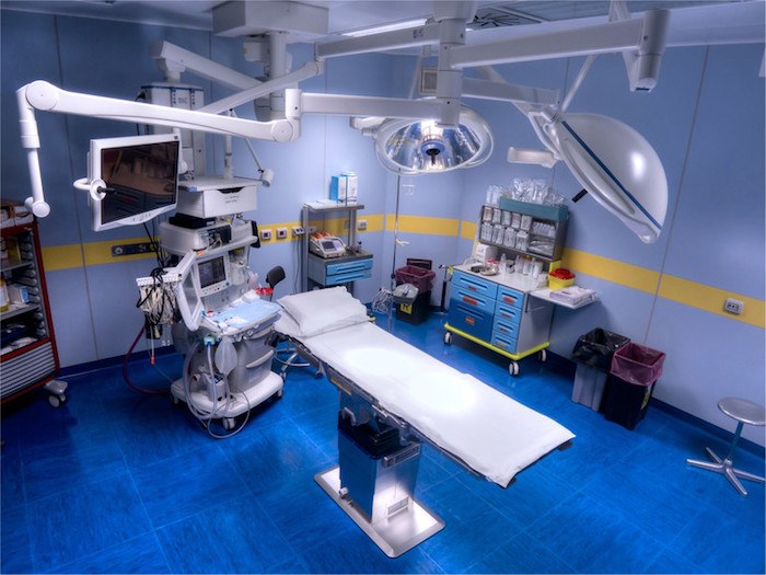 blue operating room with surgical table and operating equipment