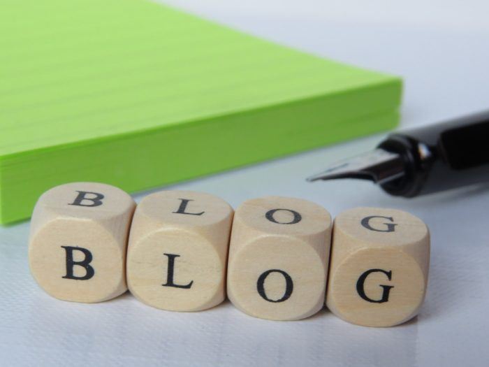 image of wooden blocks with the word "blog" and a green notepad with ink pen