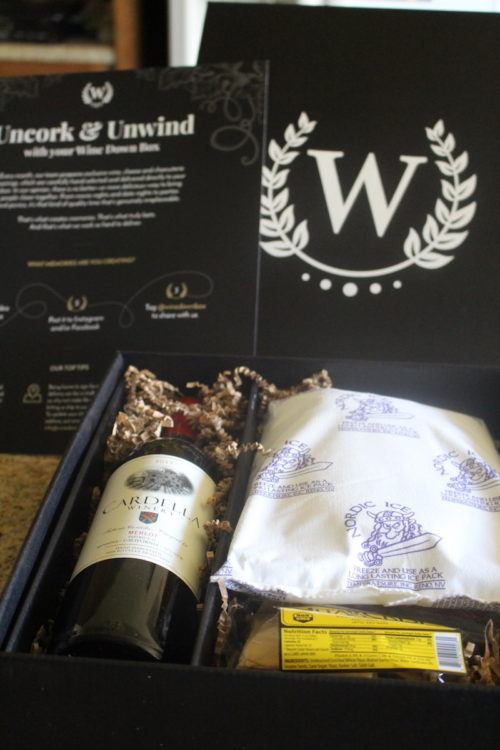 wine subscription box with bottle of wine, ice pack, cheese, and salami