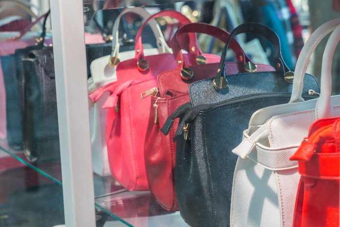 row of designer handbags sitting in a boutique shop