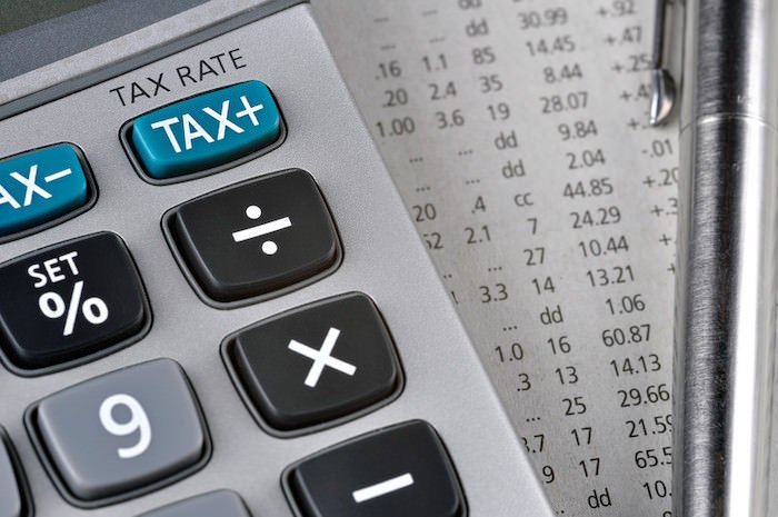 close up image of calculator with tax numbers on paper behind it representing tax preparation affiliate programs