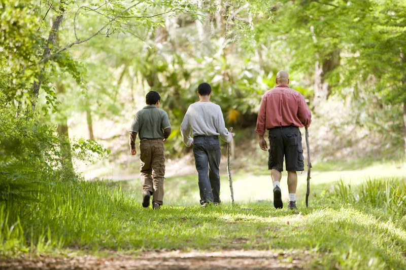 dad and two sons walking in the forest representing the struggle of how single dads cannot find the time to earn extra money