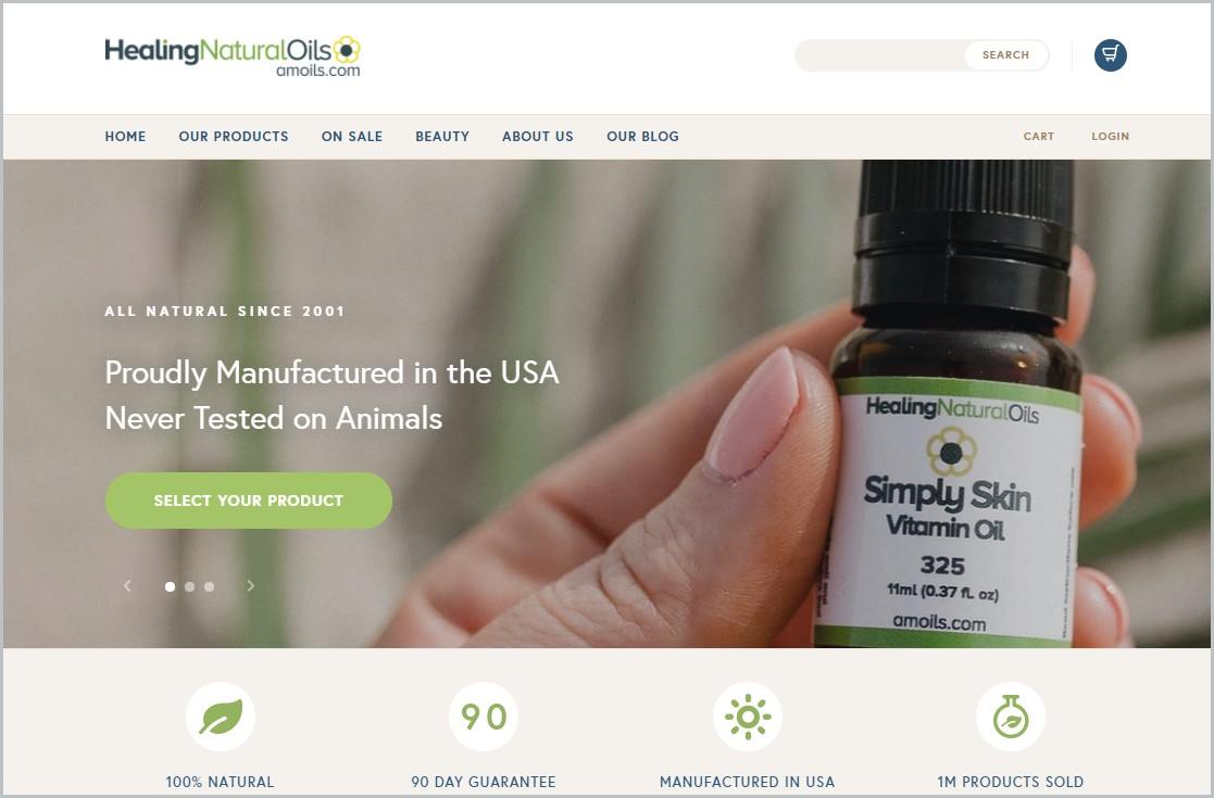 screenshot of Healing Natural Oils (Amoils) homepage showing a closeup image of a hand holding a small bottle with essential oil