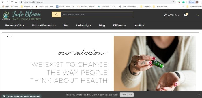 This screenshot for the home page of Jade Bloom has a dark header with the Jade Bloom logo and navigation links, a white background, and a photo of a woman pouring a drop of an essential oil onto her hand from a green glass bottle.