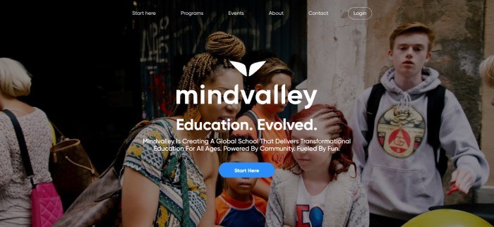 This screenshot of the home page for Mind Valley shows a dark-filtered photo of a woman talking with a few children, as the background to the white-lettered words, "Mind Valley-Education, Evolved."