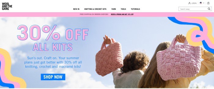 This screenshot of the home page for Wool and the Gang shows a blue sky and the backs of two women who are holding knitted bags as they walk away from the camera, along with some squiggled graphics in yellow, pink, and royal blue and a 30% off advertisement for kits in pink and blue lettering.