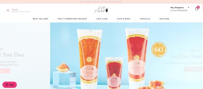 This screenshot of the home page for 100% Pure shows a set of Blood Oranges skincare products, which come in white tubes with a photo of a blood orange wrapping around it, and the products are set against a light blue background with blood orange slices and a cube of glass or ice.