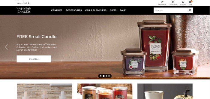 This screenshot of the home page for Yankee Candle shows three red-colored candles in jars sitting on a shelf.