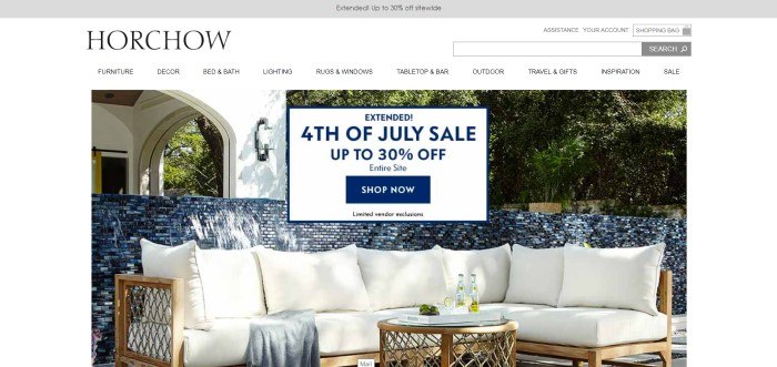 This screenshot of the home page for Horchow shows a white sectional outdoor sofa in front of a blue tiled wall and a white arched doorway, with a fourth-of-July advertisement laid over the top of the picture.