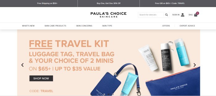 This screenshot of the home page for Paula's Choice Skincare has a white background and a beige text box with dark peach lettering that introduces a free travel kit for skin care products, along with a photo of three bottles of skin care products and a blue leather-look bag to put them in.