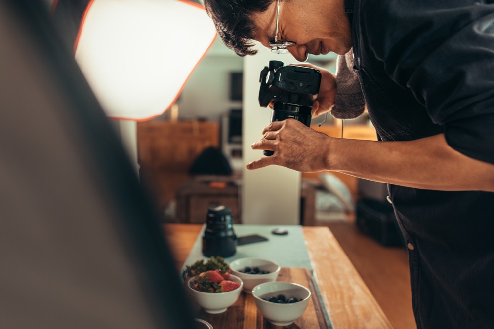 man with DSLR camera photographic dishes for his food blog