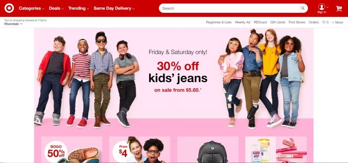 This screenshot of the home page for Target has a red navigation bar above a mostly pink background with several pictures of smiling school-aged children and back to school products, along with an advertisement in red and black text for 30% off children's jeans.