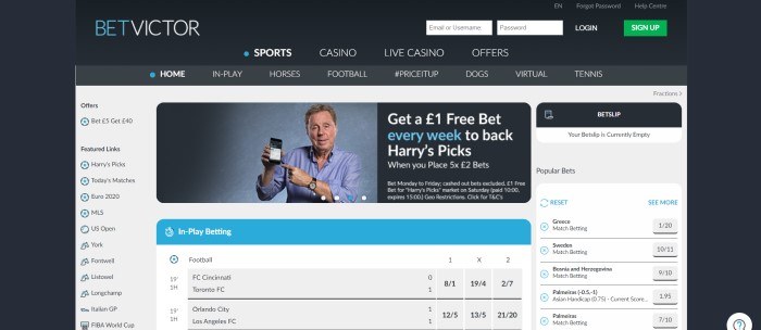 This screenshot of the home page for BetVictor has a black background with a gray, white, and light blue section in the middle with a photo of a man holding up his cell phone as if he's using it to place bets. 