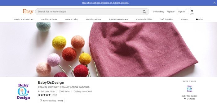 This screenshot of the home page for Baby Q's designs shows a rose-colored beanie hat along with several felt balls in green, orange, red, yellow, and pink, below a white header with the Etsy logo and a blue bar announcing free shipping on many items sold on Etsy.