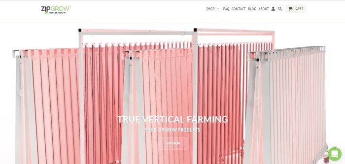 This screenshot of the home page for ZipGrow shows a few sections of ZipGrow towers in pink with white frames, behind text in white lettering that reads 'True vertical farming.'