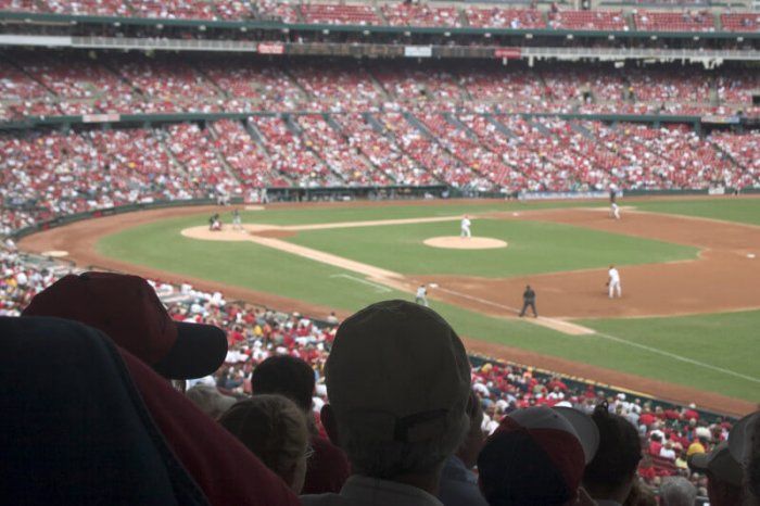 A baseball stadium with people packed into the stands and a game in session