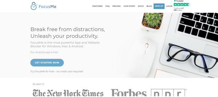 This screenshot of the home page for Focus Me has a white navigation bar above a central gray section with an overhead photo of a desk top with a cactus, glasses, and laptop, near black text inviting consumers to break free from distractions with Focus Me.