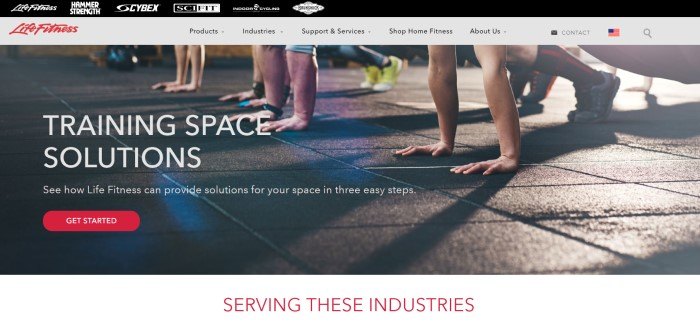 This screenshot of the home page for Life Fitness shows the hands and feet of a row of four people ready to do pushups on a dark tiled floor, near white text that reads "training space solutions" and a red "get started" call-to-action button.