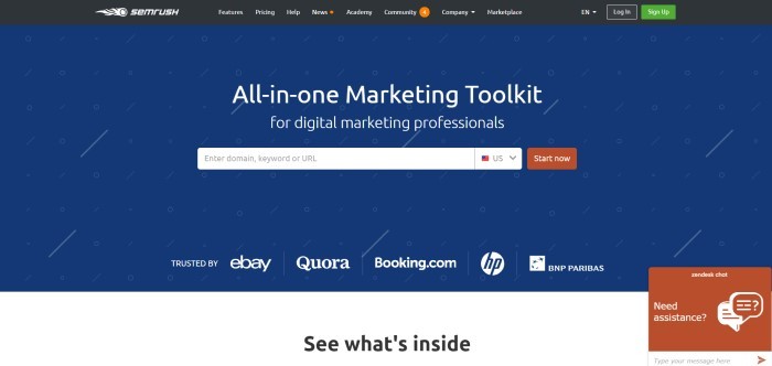 This screenshot of the home page for SEMrush shows a dark blue background with white circles and diagonal slashes behind white text announcing SEMrush as an all-in-one marketing toolkit and a rust-colored 'Start now' call-to-action button.