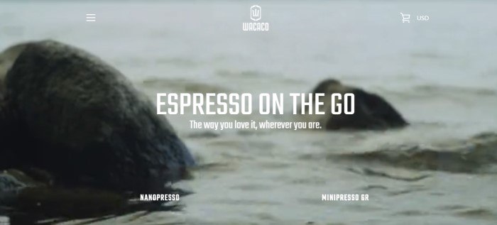 This screenshot of the home page for Wacaco has a grayish photo of two rocks in the water, behind white text which reads "Espresso on the go: The way you love it, wherever you are."