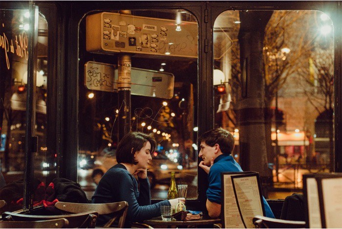 A young couple sitting in a coffee shop in the evening