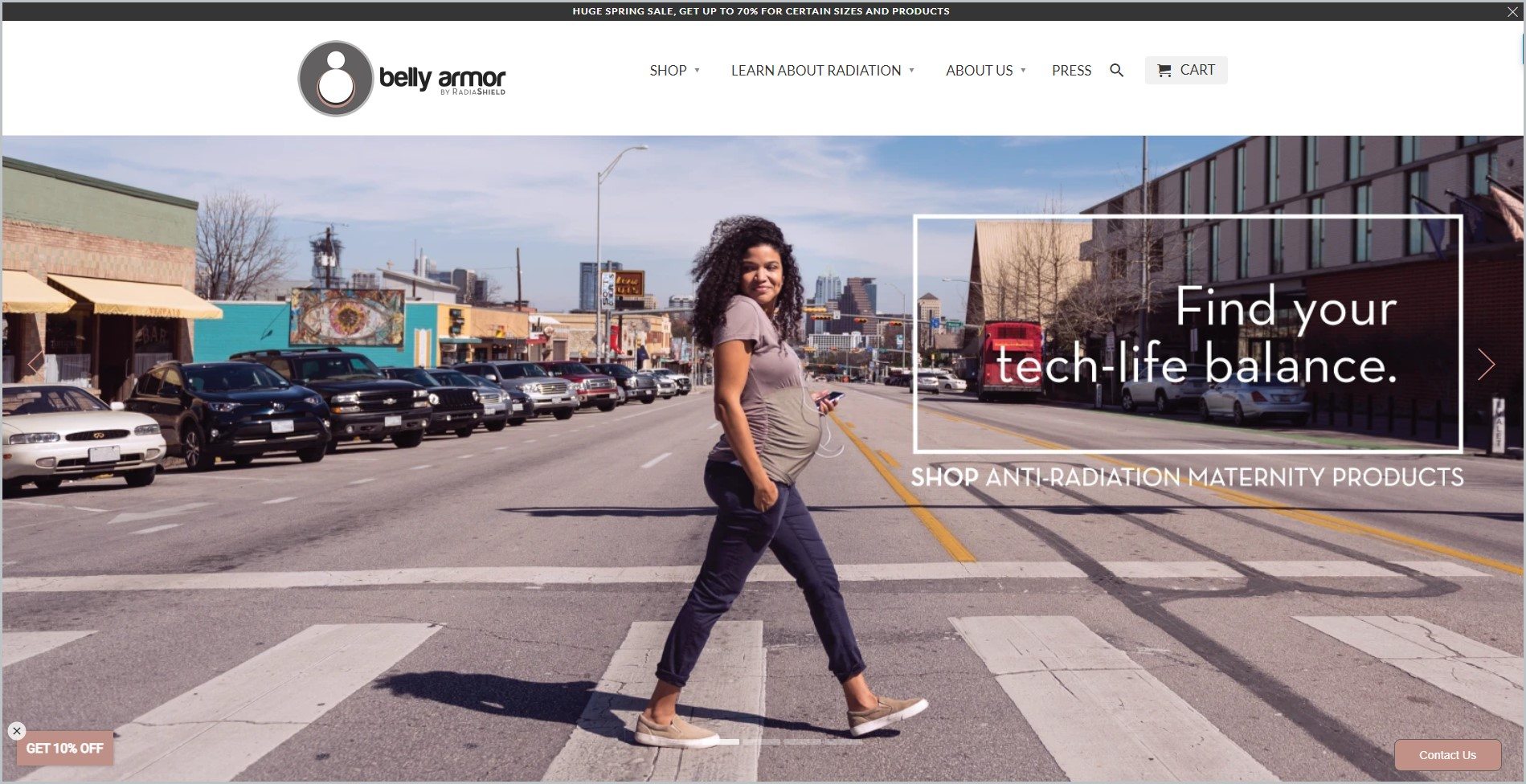 screenshot of Belly Armor homepage with black announcement bar, white header with the website's name and main navigation menu, it also showcases a smiling pregnant black woman, crossing a pedestrian lane