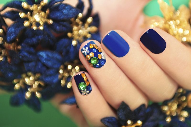 A close up image of blue nail art on a woman's hand