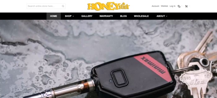 This screenshot of the home page for HoneyStick has a white header with a yellow logo, a black navigation bar, and a black and red minimax vaporizer keychain with keys lying on what looks like a gray table with water spilled on it. 