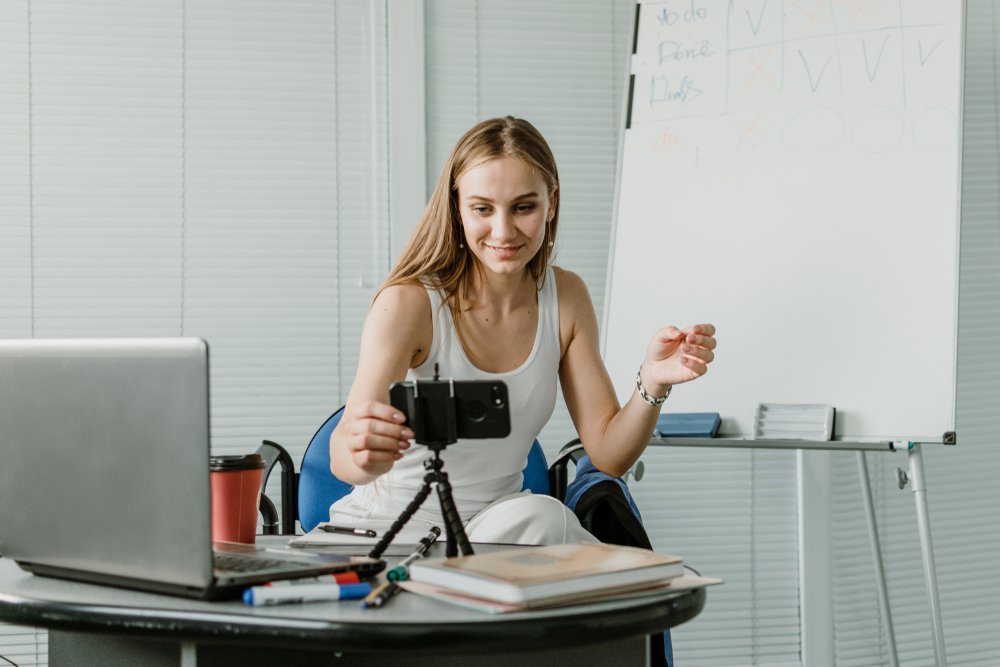 A young woman setting up to record herself via webcam